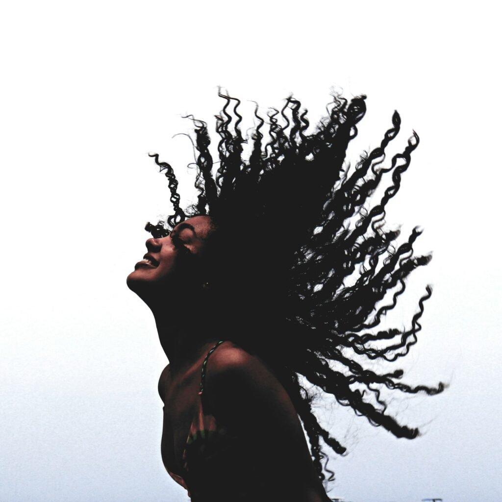 woman in black tank top standing beside leafless tree during daytime. Image Credit: Adrian Fernandez | Unsplash