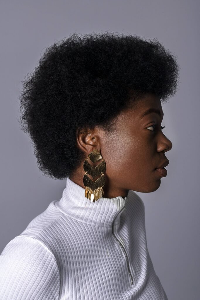 woman wearing white turtleneck top and gold-colored earring. Image Credit: Juan Manuel Merino | Unsplash